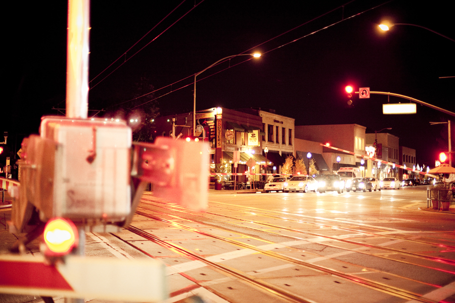 Pasadena train/ road intersection at night.