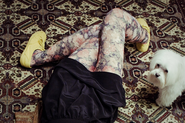 Urban Outfitters floral tights and yellow soled sneakers on carpet.