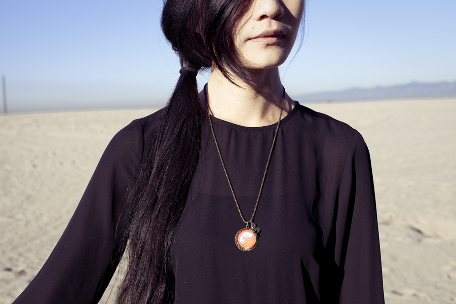 Detail of my etsy narwhal necklace and H&M black chiffon dress.
