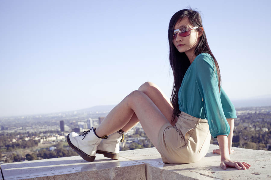 Perched on the ledge of the Getty Center. Outfit details: Forever21 chiffon green tan romper, La Marelle pink bow metal necklace, Uniqlo grey bra-top camisole, Dr. Martens white 8eye boots.
