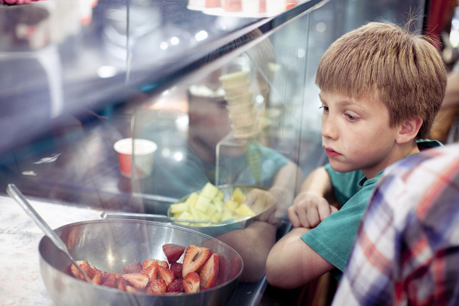 Boy looks on behind the glass pane as frozen yogurt is being made at 21 Choices in Pasadena.