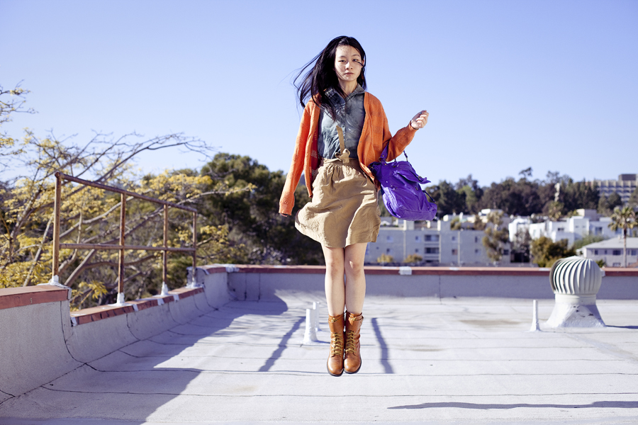 Rooftop jumping photoshoot. Wearing Urban Outfitters dyed sleeveless top with studded collar, Forever 21 orange perforated boyfriend cardigan, Zara brown front-tie skirt with pockets, green crocodile socks, Top Shoes brown zippered boots, T-shirt & Jeans leatherette purple sling bag.