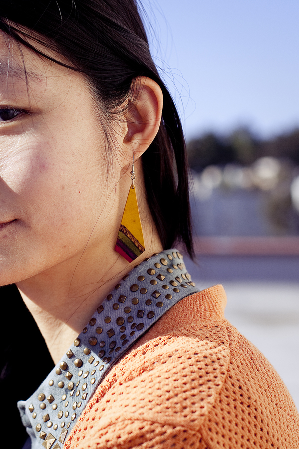Rooftop photoshoot. Detail of Urban Outfitters dyed sleeveless top with studded collar, Forever 21 orange perforated boyfriend cardigan, yellow wooden earring handmade from a stall in Buenos Aires, Argentina.