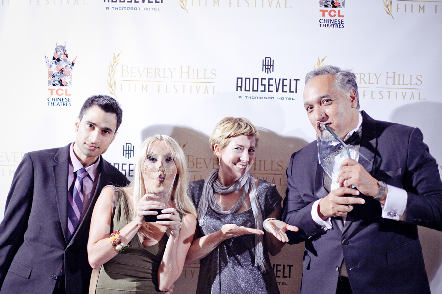 Kissing the awards in front of the backdrop at the Beverly Hills Film Festival awards ceremony at the Four Seasons Hotel.
