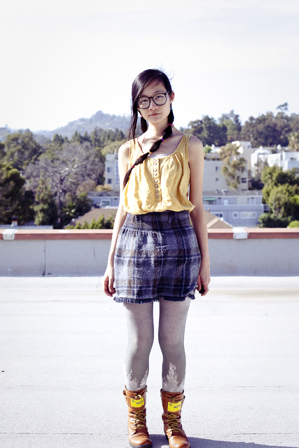 Rooftop self portrait. Composited photo. Outfit of the Day: Forever 21 yellow sleeveless top, Urban Outfitters printed tights, Top Shoes brown boots, Zara navy plaid wool skirt, black rimmed hipster glasses.
