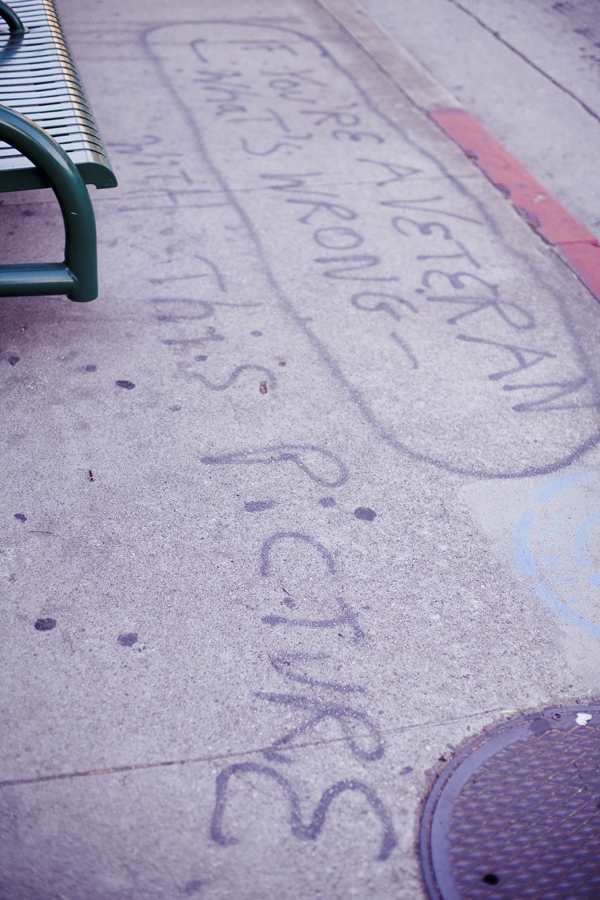 Graffiti on the pavement at a bus stop near the Los Angeles National Cemetery.