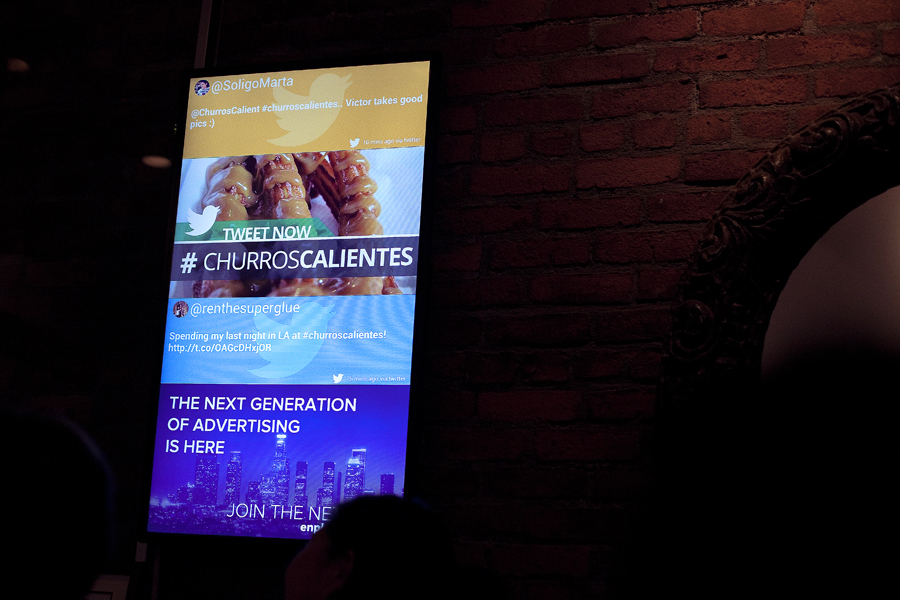 Marta and Ren's tweets tagged #churroscalientes on display at a digital screen in Churros Calientes.