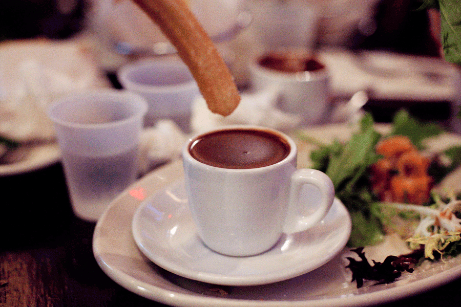 Animated gif of a handmade churros dipped into hot chocolate at Churros Calientes.