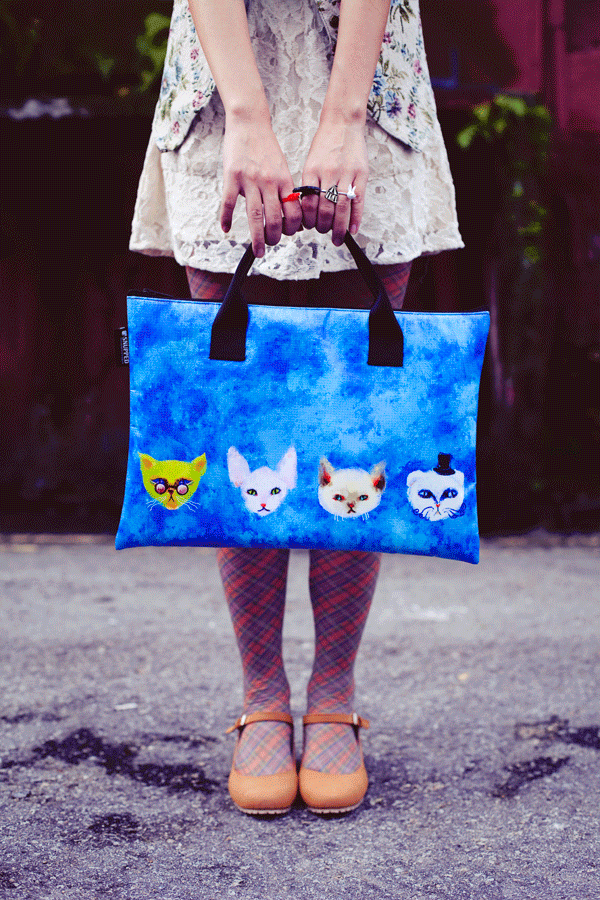 Animated gif of Ren twirling a custom-made Snupped laptop sleeve with handles. Cats designed by pupuren.