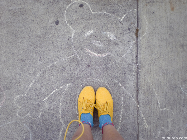 Chalk drawing of a bear on the pavement.