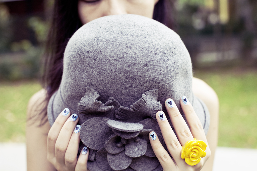 Wool hat, painted blue nails, yellow rose plastic ring.