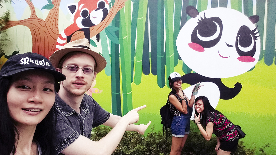 Friends and I in front of a stylised panda wall at the River Safari.