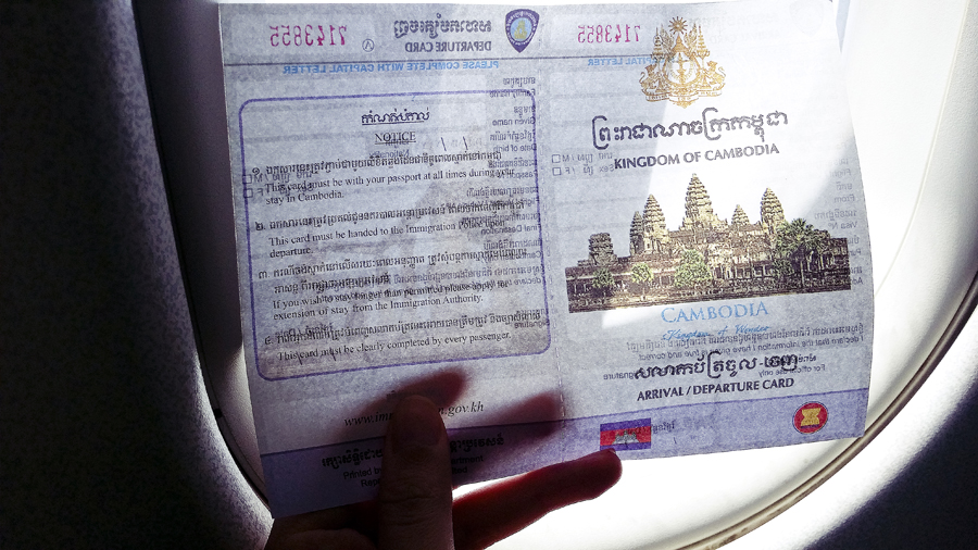 On a plane, holding an arrival card to enter Cambodia.