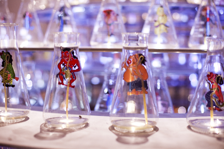 Detail of Between Worlds by Nasirun. An installation with leather puppets in glass bottles.