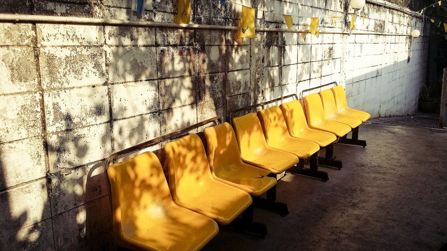 Yellow chairs by the dock at Chao Phraya River in Bangkok, Thailand.