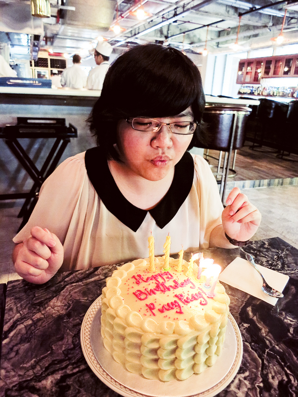 Puey blowing out candles on her birthday cake at boCHINche.