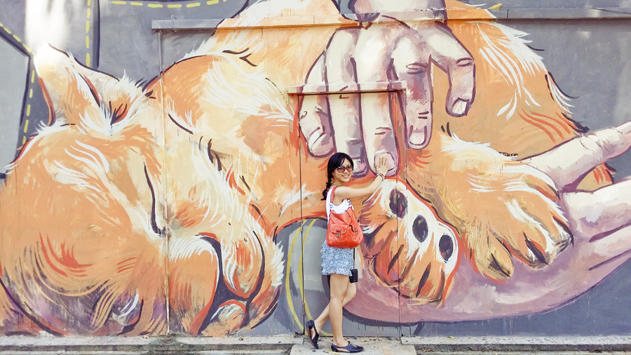 Alala posing with Girl and the Lion Cub, a mural by Ernest Zacharevic.
