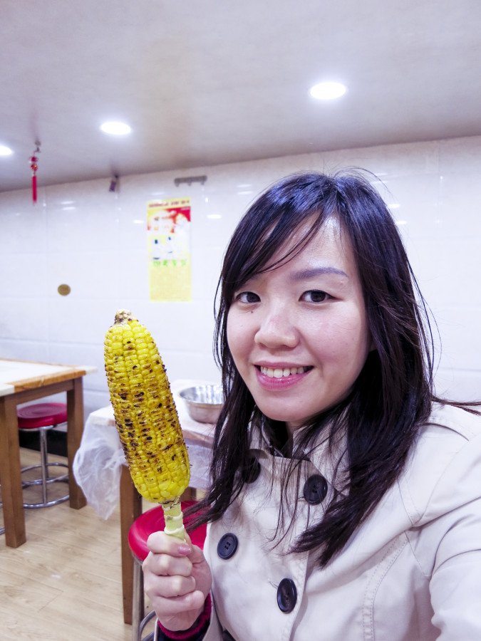 Ade posing with grilled corn in Shanghai.