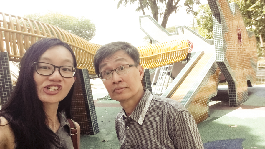 Ren and Pa making funny faces at a playground.