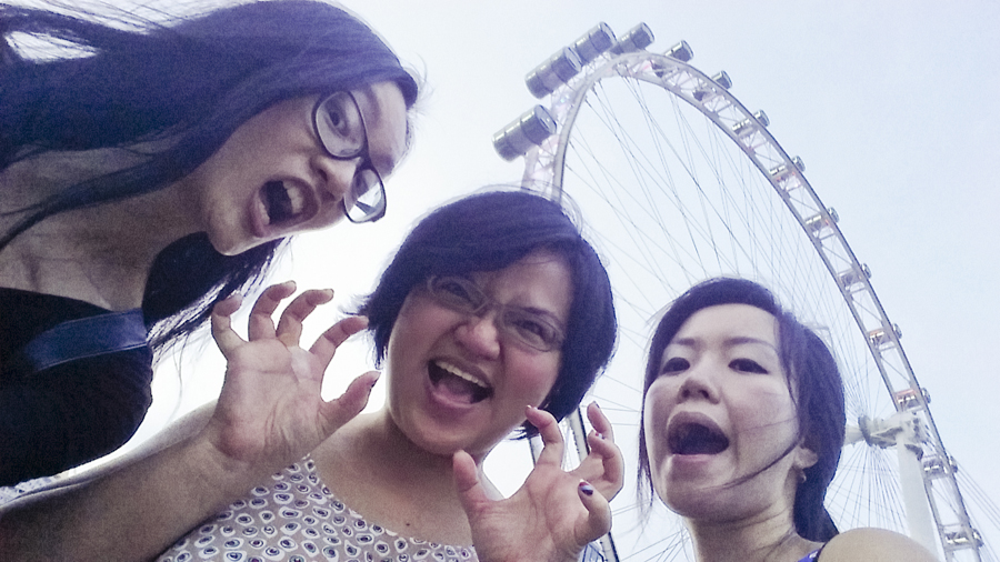 Ren, Puey, and Ade making funny scary faces in front of the Singapore Flyer.