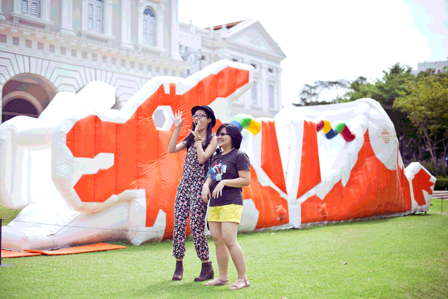 Animated gif of Ren and Puey in front of an inflatable plastic mockup of Singapore's iconic dragon playground atPuey, Ren, and Ade posing with chalk drawings at the Masak Masak exhibit at the National Museum of Singapore. Photo by Ade.