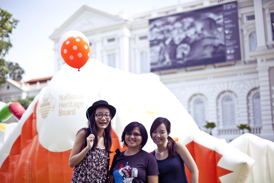 Ren, Puey, and Ade posing in front ofPuey, Ren, and Ade posing with chalk drawings at the Masak Masak exhibit at the National Museum of Singapore.