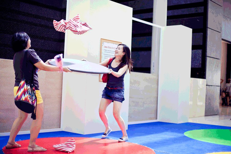 Animated gif of Ade and Puey interacting with five stones at the Masak Masak exhibit at the National Museum of Singapore.