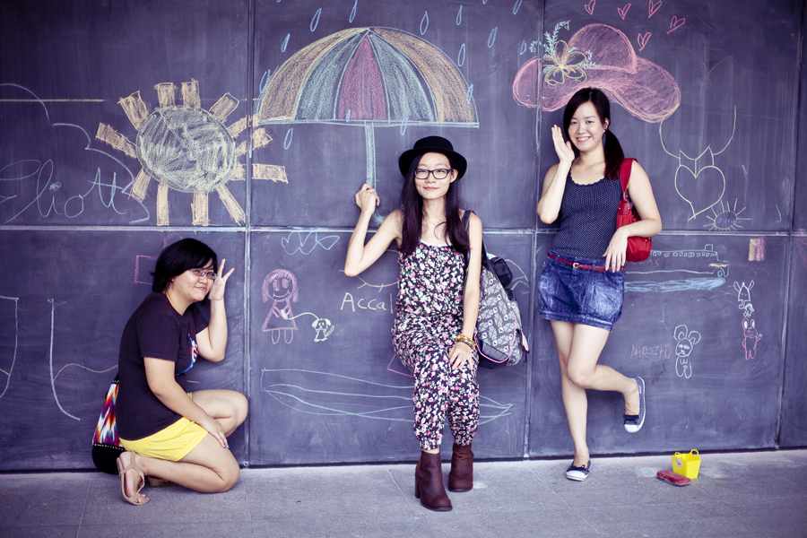 Puey, Ren, and Ade posing with chalk drawings at the Masak Masak exhibit at the National Museum of Singapore.