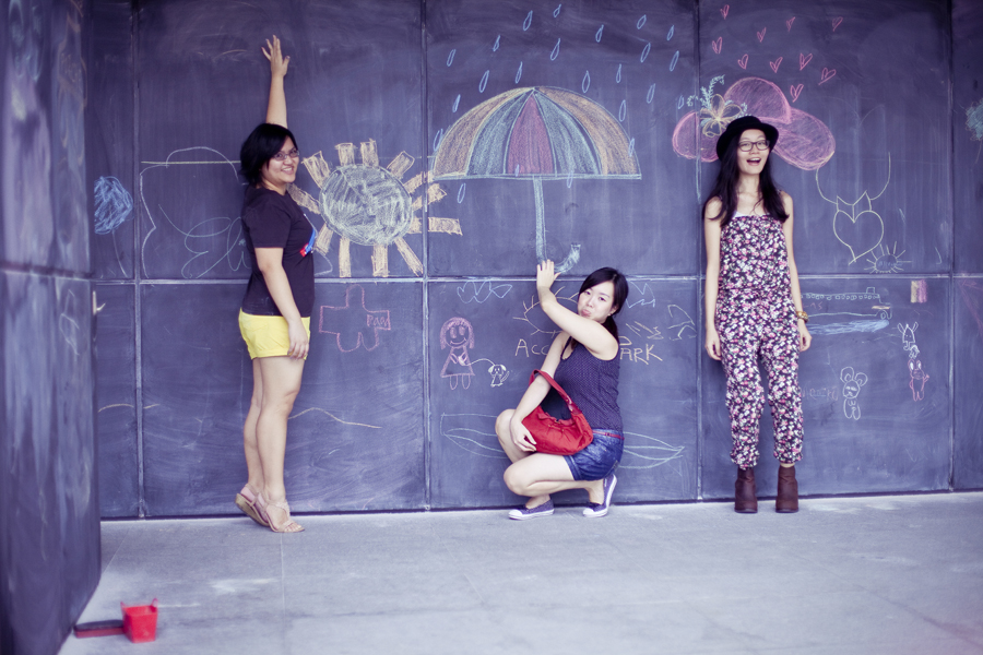 Puey, Ren, and Ade posing with chalk drawings at the Masak Masak exhibit at the National Museum of Singapore.