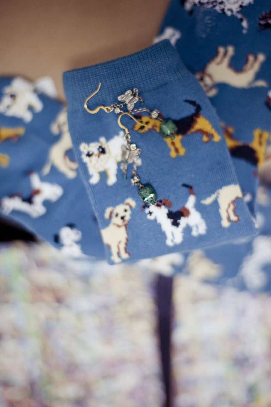 Detail of green dangly earrings and teal Taobao dog print socks