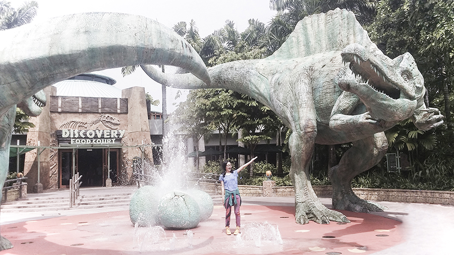Posing with dinosaur sculptures at Jurassic Park at Universal Studios Singapore.