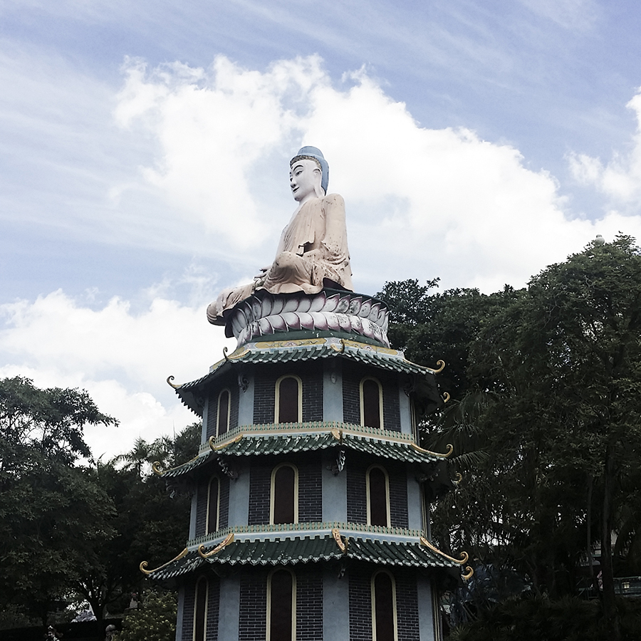 Statue of buddha atop a pagoda at Haw Par Villa, Singapore.