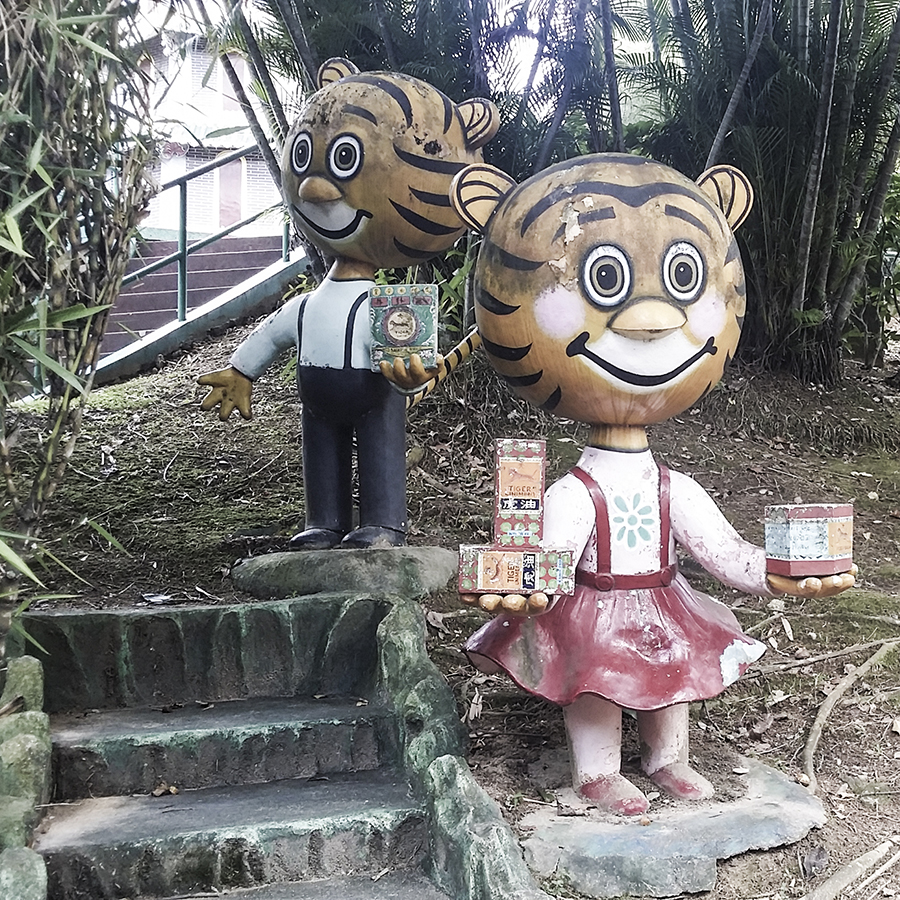 Cute tigers holding Tiger Balm products at Haw Par Villa, Singapore.