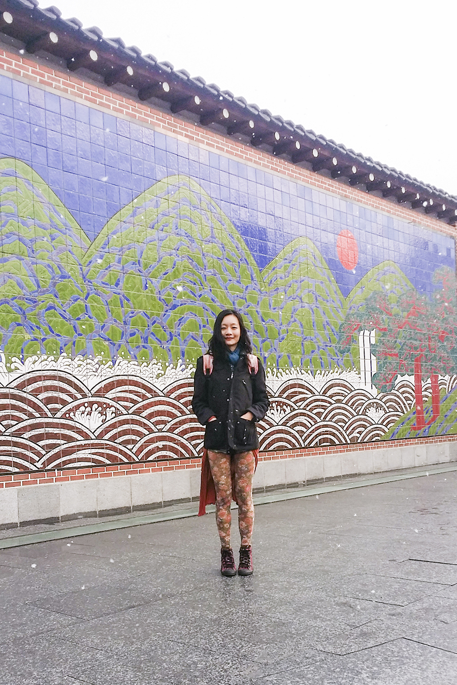 Outfit photo against a tiled wall of a landscape mosaic in Seoul, South Korea.