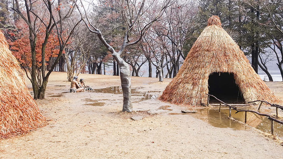 Thatched huts with sculptures of tribal humans at Nami Island, Gapyeong, South Korea.