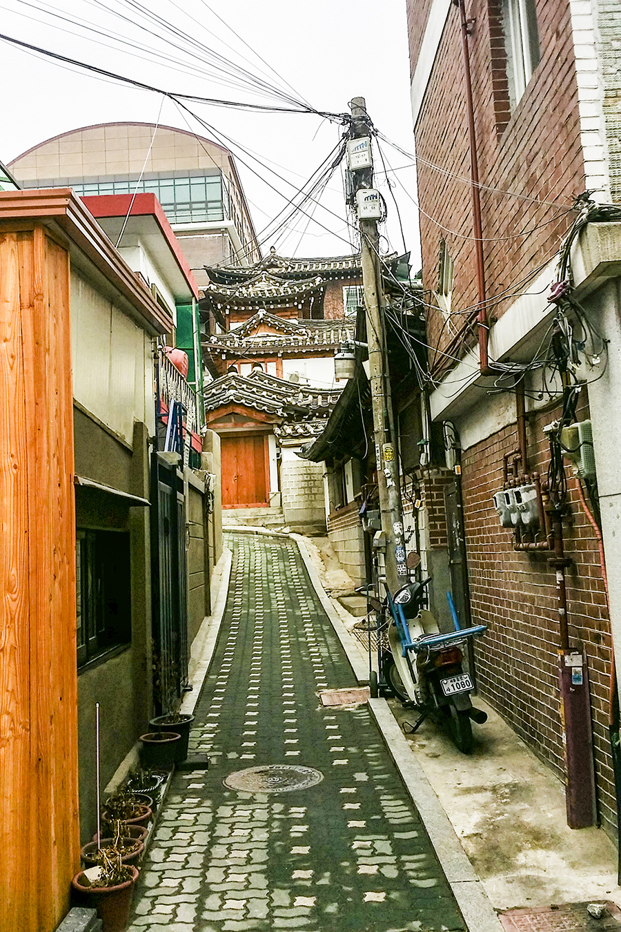 Historical architecture up a slope as viewed from a main street in Bukchon, South Korea.