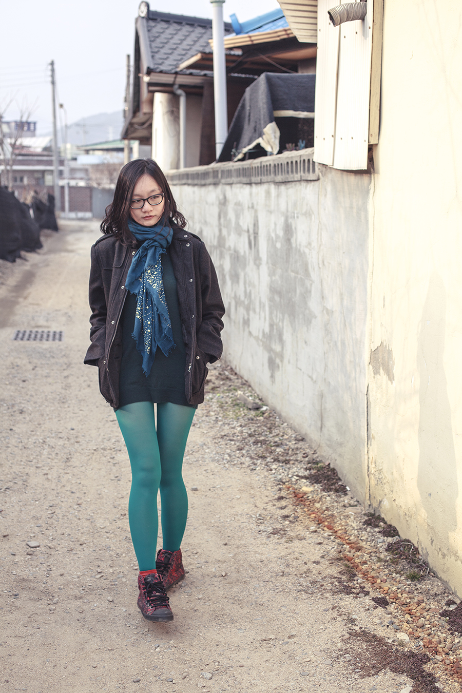 Outfit in green: H&M merino wool sweater in green, Marshalls blue shawl with gold studs, teal tights, H&M men's jacket, black rimmed Gap glasses, Twisted Sisters eye motif Caren Bracelet via Zalora, Alexander McQueen x Puma high top sneakers.