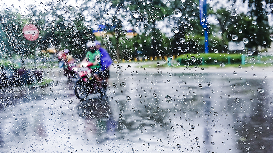 Motorcyclists through raindrops in Batam, Indonesia.