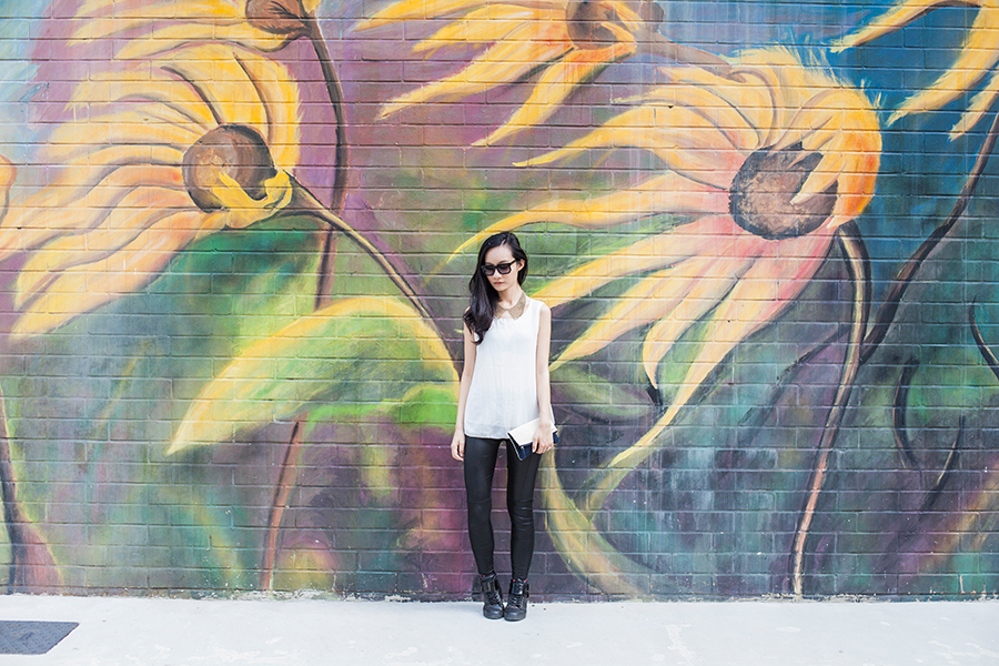 Monochrome chic outfit against sunflower mural.