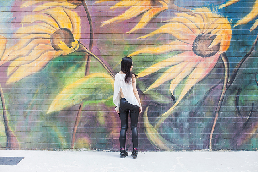 Monochrome chic outfit against sunflower mural.