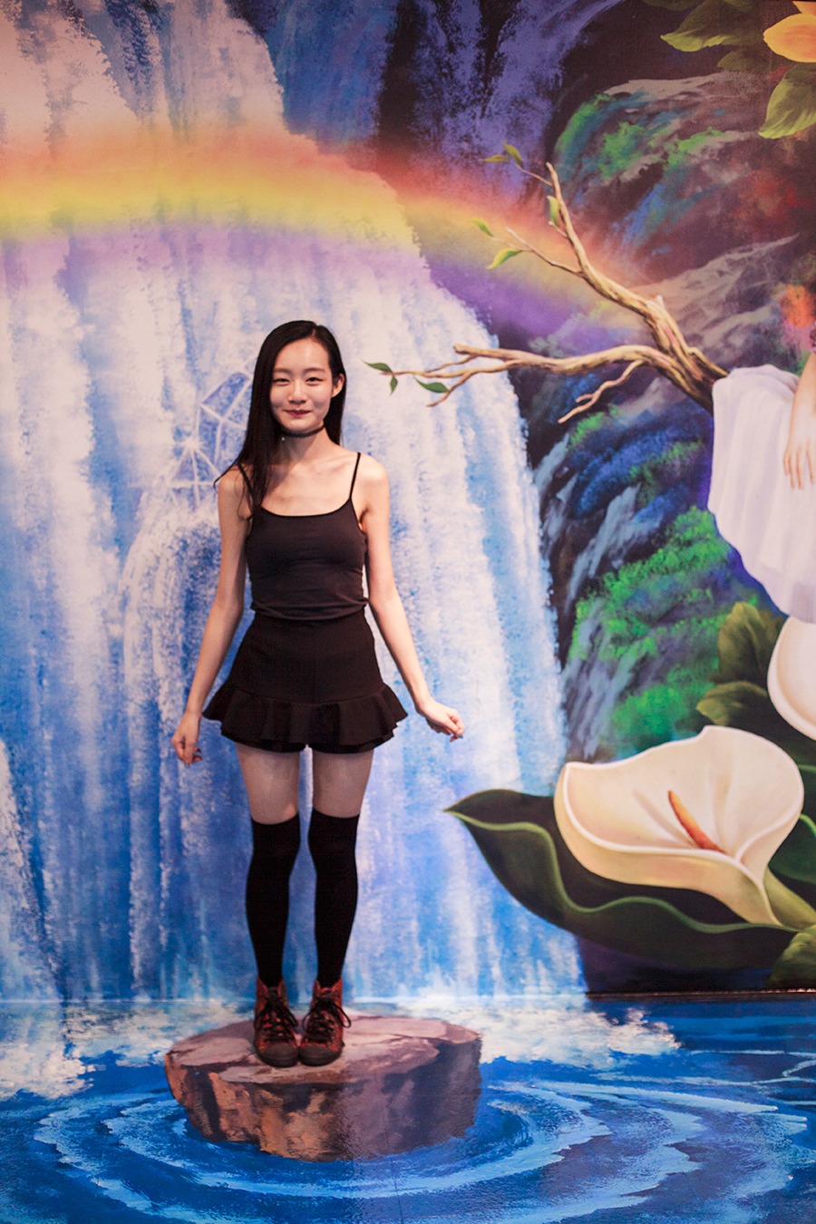 Standing on a log in front of a fairytale scene trompe-l'œil at the Trick Eye Museum Renewal Event in Singapore, Resorts World Sentosa.