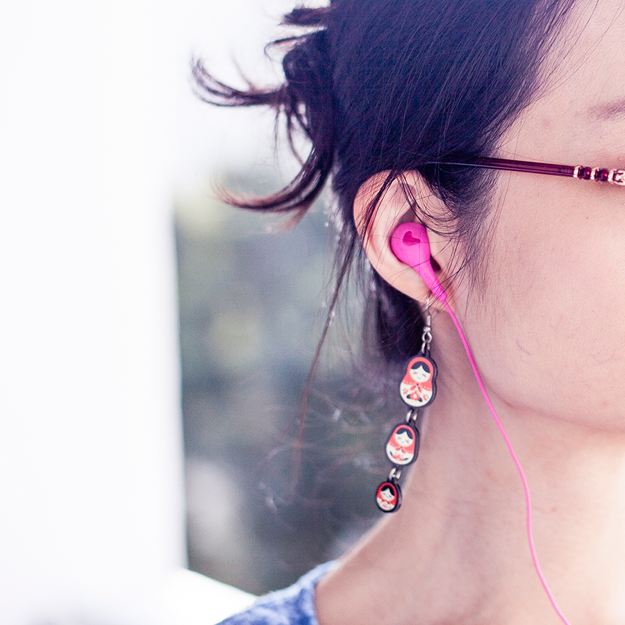 Matryoshka earrings and hot pink iLuv earphones.