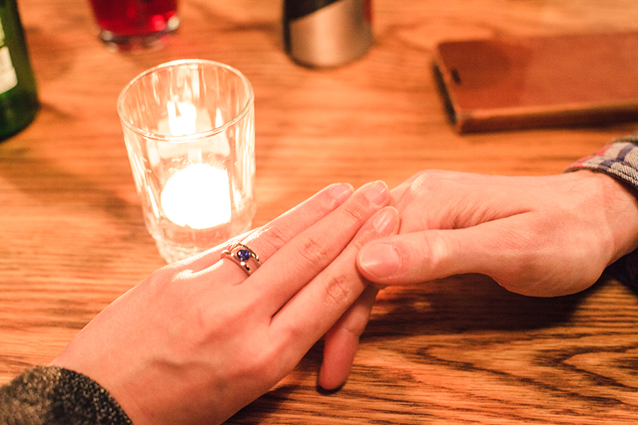 Intertwined fingers with sapphire engagement ring in Cape Town.