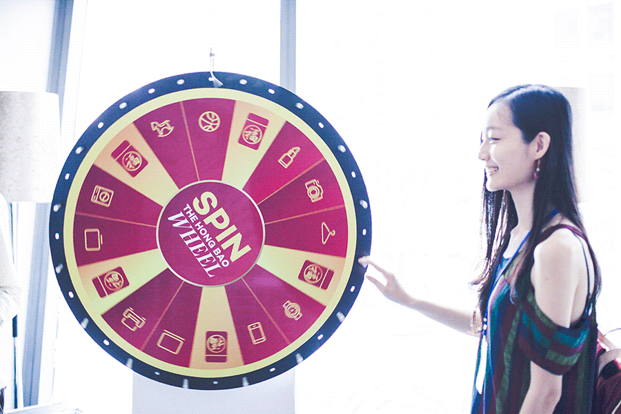 Animated gif of Ren spinning the Chinese New Year Hong Bao Wheel at the Lazada Singapore's Blogger Bazaar.