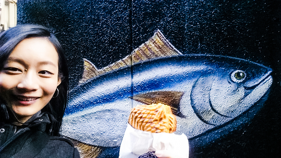 Taiyaki in front of a fish mural in Osaka, Japan.