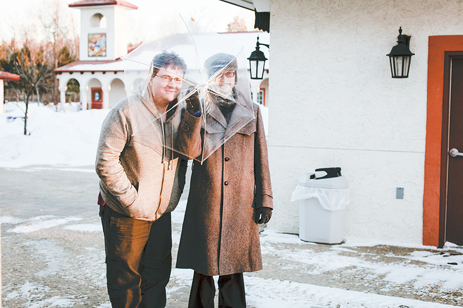 Jeff & Ottie hiding behind a transparent umbrella.