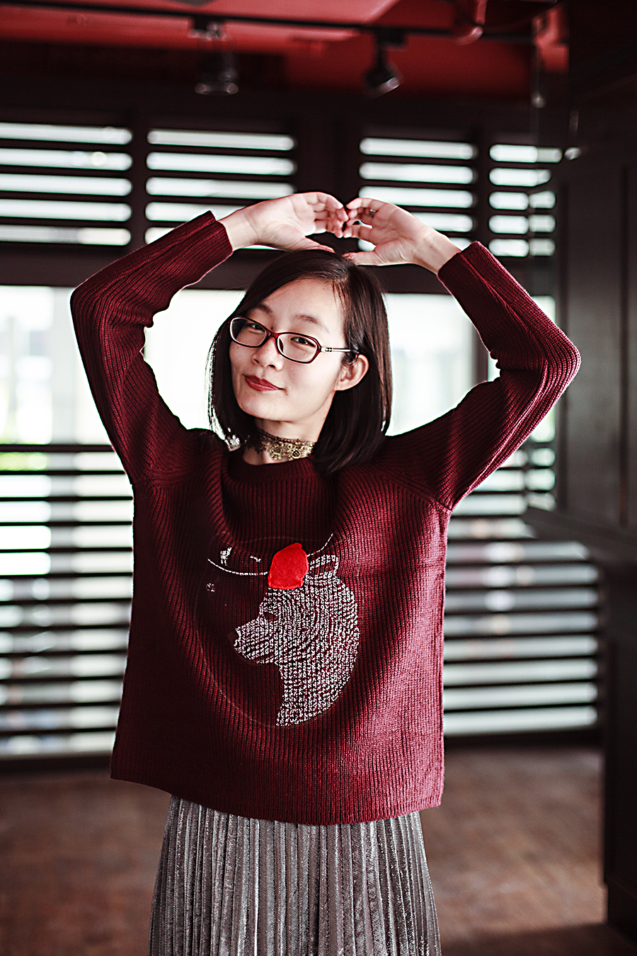 Making a heart shape with my arms in my bear sweater.