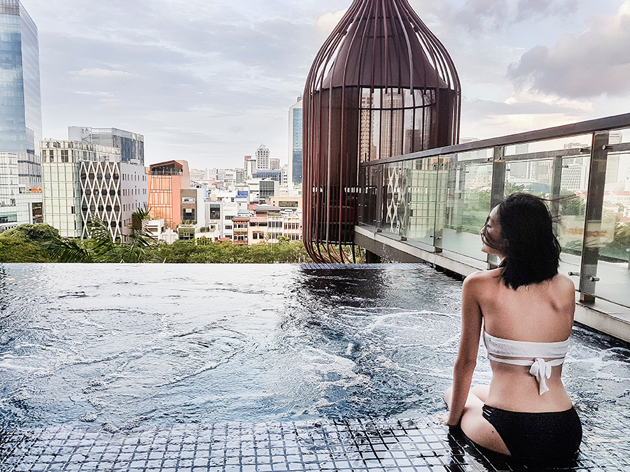 Lounging by the jets at the infinity pool at hotel PARKROYAL on Pickering, Singapore. Wearing Piha white wrap lace bikini top, Bella Kini black lace bottoms.