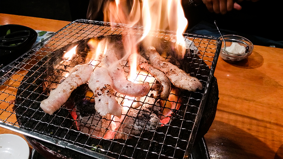 Grilling beef yakiniku at Fuu Fuu Ten in Osaka, Japan.