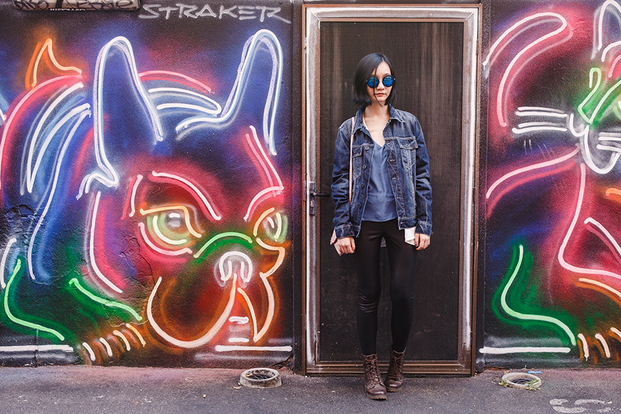 Denim leather outfit in front of a neon lights mural in Perth Australia.